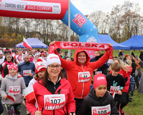 na zdjęciach bieg biało-czerwony, uczestnicy na trasie oraz wręczenie nagród na podium