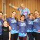 Galeria zdjęć z zajęć taneczno-fitness (Zumba) – wspólna rozgrzewka i choreografie prowadzone przez instruktorkę, aktywność uczestników w sali oraz integracyjne ujęcia zespołu MOSiR.