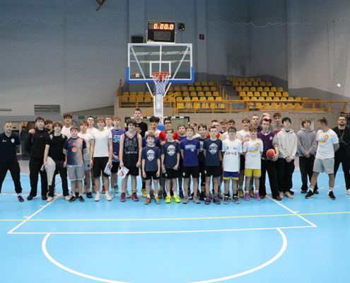 Galeria zdjęć z treningu koszykówki młodzieży w hali sportowej – ćwiczenia techniczne, dynamiczne akcje pod koszem, rzuty z wyskoku oraz gra szkoleniowa zespołów.