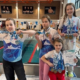 Galeria zdjęć przedstawia młodych zawodników OLYMPIC.GYM podczas zawodów pływackich w Siemianowicach Śląskich. Na fotografiach widoczni są uczestnicy z medalami i dyplomami, momenty dekoracji na podium oraz zawodniczka podczas pobytu na basenie.