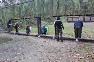 Na zdjęciu strzelcy sprawdzający wyniki prób strzeleckich na swoich tarczach