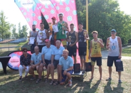 Na zdjęciu zwycięzcy turnieju siatkówki plażowej na podium z nagrodami ustawieni do zdjęcia grupowego