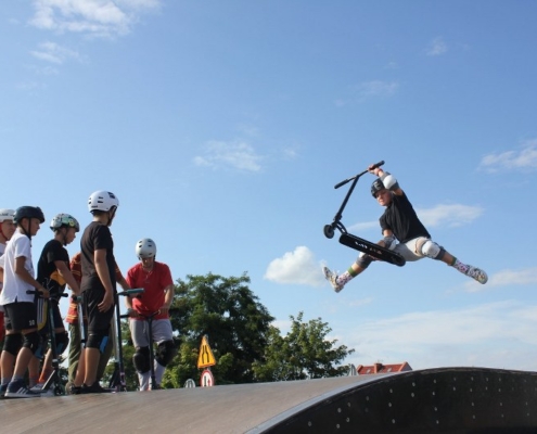 na zdjęciu uczestnik szkółki w efektownym triku na rampie w żorskim skate parku