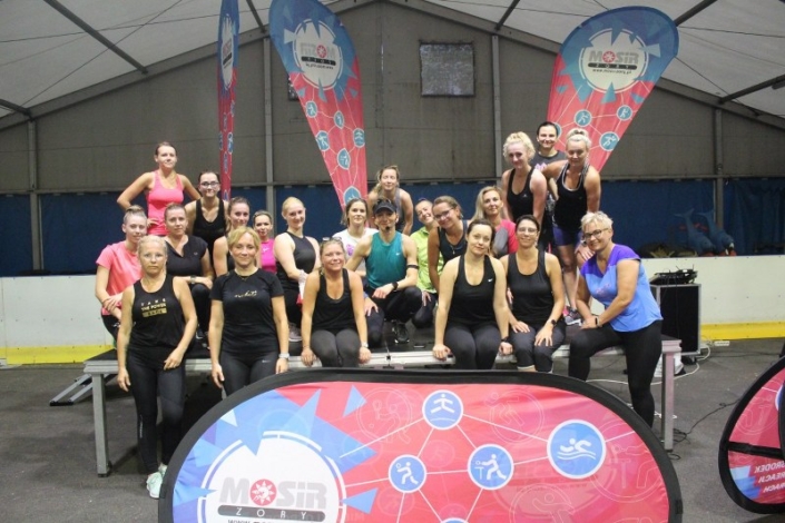 na zdjęciu grupa uczestniczek zajęć fitness z instruktorką w namiocie lodowiska ustawiona do zdjęcia