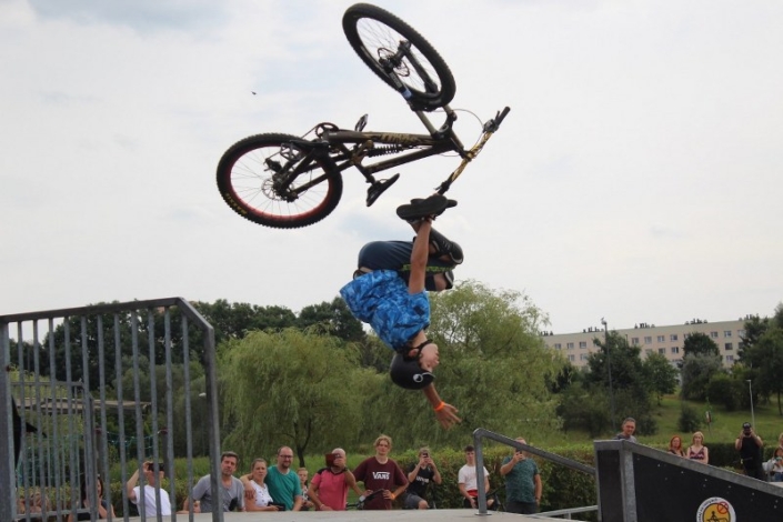 na zdjęciu zawodnik na rowerze wykonujący trick na skate parku