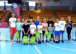 na zdjęciu grupa uczestników szkółki tenisa w zdjęciu grupowym w hali sportowej