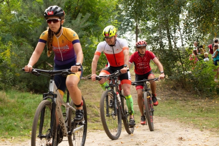 na zdjęciu trzech kolarzy podczas jazdy na trasie żorskiego cross triathlonu