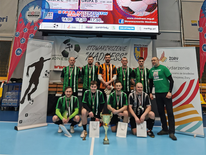 na zdjęciu zwycięska drużyna turnieju futsala w hali sportowej z nagrodami