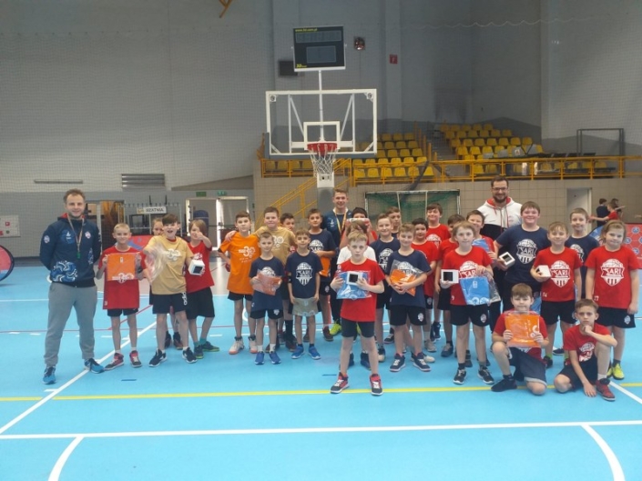 na zdjęciu grupowym uczestnicy turnieju koszykówki z nagrodami w hali sportowej
