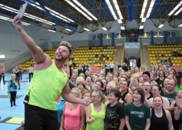 na zdjęciu w hali sportowej Daniel Qczaj robiący selfie z uczestnikami zajęć fitness