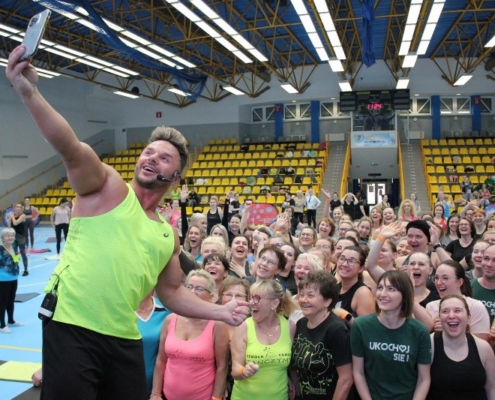 na zdjęciu w hali sportowej Daniel Qczaj robiący selfie z uczestnikami zajęć fitness