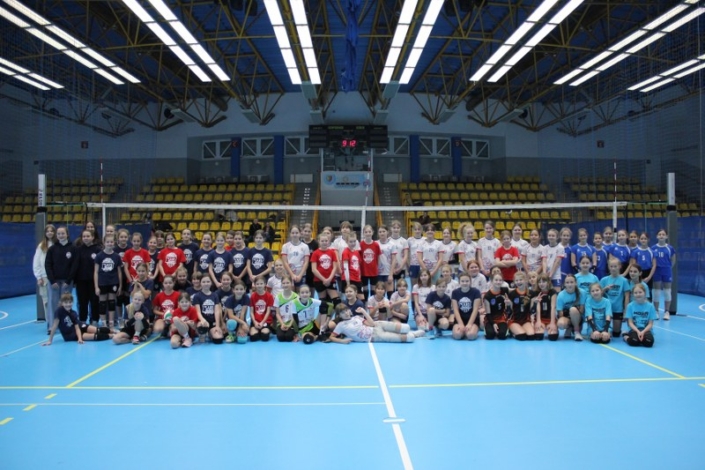 na zdjęciu grupowym uczestniczki turnieju siatkówki dziewcząt w hali sportowej