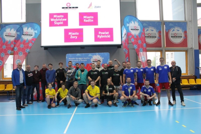 na zdjęciu grupowym uczestnicy turnieju siatkówki w hali sportowej