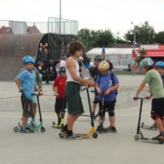 na zdjęciu uczestnicy zajęć szkółki hulajnogi na skate parku