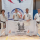 na zdjęciach turniej karate w hali sportowej i zawodnicy z banerem