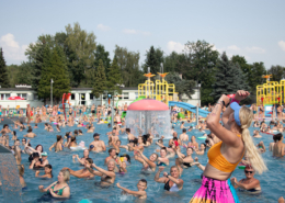 na zdjęciu basen, odwiedzający i uczestniczący w zajęciach ruchowych nad wodą oraz inne atrakcje