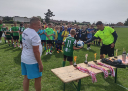 na zdjęciach turniej piłki nożnej na stadionie, zawodnicy w grupie i podczas rozgrywek oraz wręczenie nagród