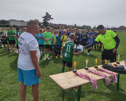 na zdjęciach turniej piłki nożnej na stadionie, zawodnicy w grupie i podczas rozgrywek oraz wręczenie nagród