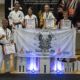 na zdjęciach zawody karate w hali sportowej, wręczenie nagród i zawodnicy na podium