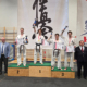 na zdjęciach turniej karate w hali sportowej i wręczenie nagród na podium