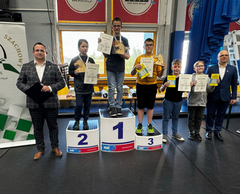 na zdjęciach dzieci podczas turnieju szachowego w hali sportowej i na podium z nagrodami
