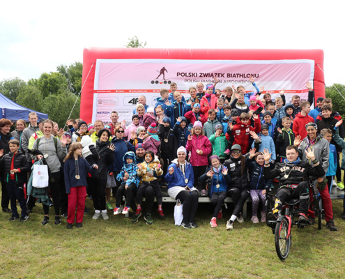 galeria zdjęć przedstawia zawody biathlonowe, biuro zawodów, strzelanie do celu i zdjęcia na podium z nagrodami oraz rozgrzewkę