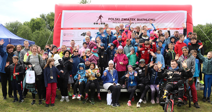 galeria zdjęć przedstawia zawody biathlonowe, biuro zawodów, strzelanie do celu i zdjęcia na podium z nagrodami oraz rozgrzewkę