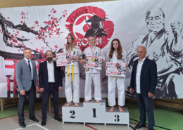 galeria zdjęć przedstawia turniej karate w hali sportowej i wręczenie nagród na podium