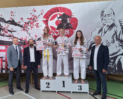 galeria zdjęć przedstawia turniej karate w hali sportowej i wręczenie nagród na podium