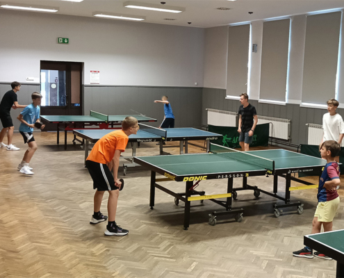 galeria zdjęć przedstawia turniej tenisa stołowego w salce sportowej