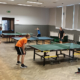 galeria zdjęć przedstawia turniej tenisa stołowego w salce sportowej
